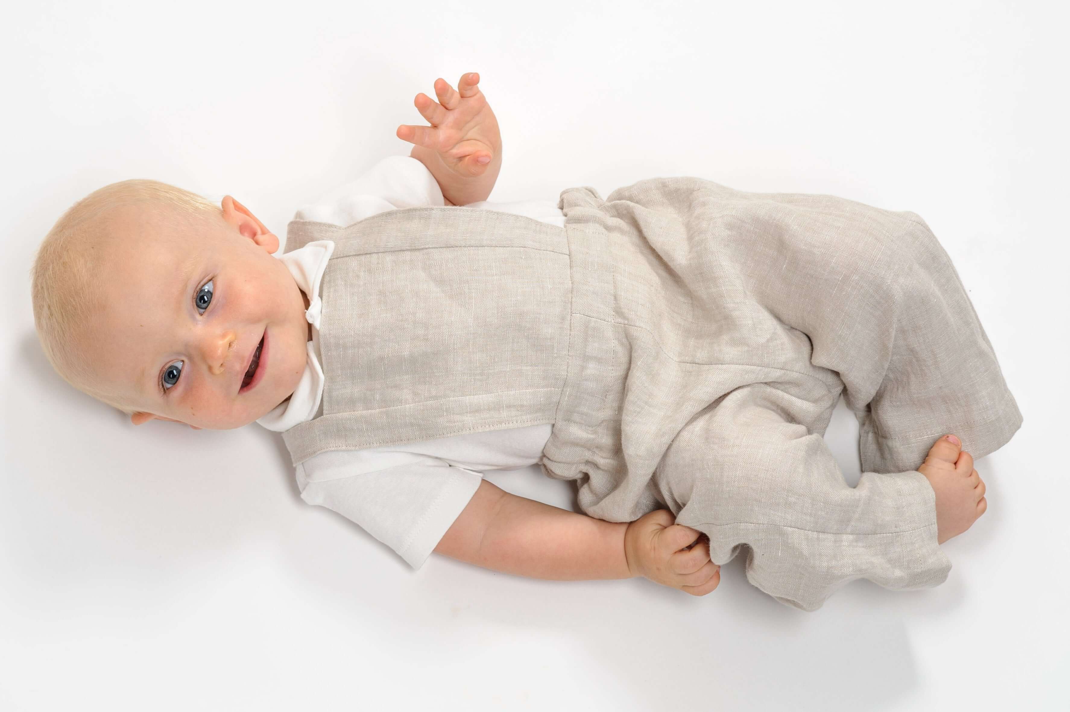 Schnittmuster Latzhose für Babys, MAX in hellen Stoff, bequem und bewegungsfreundlich für aktive Kinder.