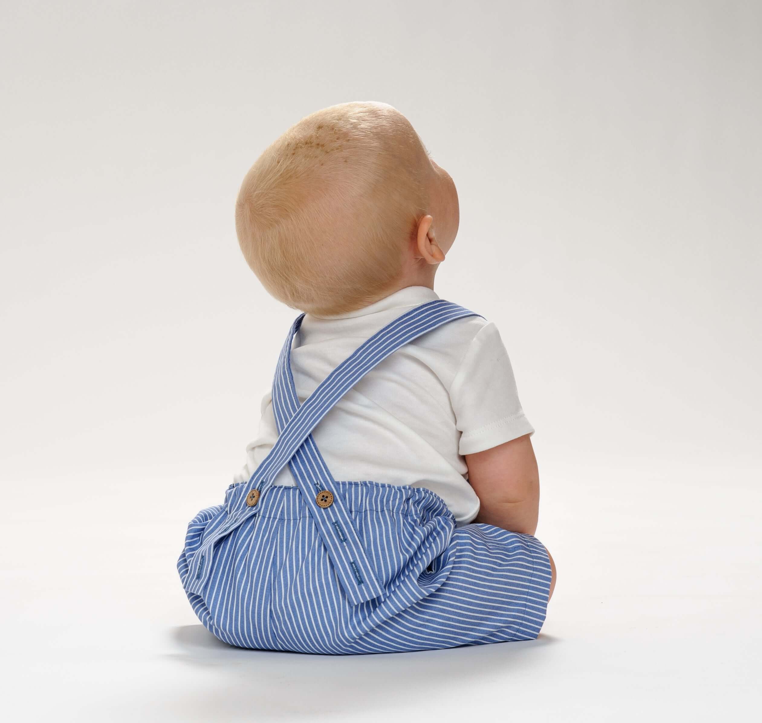 Schnittmuster Latzhose MAX – Baby in blauer gestreifter Latzhose mit Trägern, geeignet für Sommer und Winter.