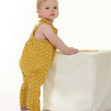 Schnittmuster Baby Overall Jumpsuit NELE – Kleinkind in gelbem Overall mit Pünktchen, stehend an einem weißen Würfel.
