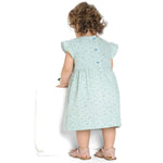 Schnittmuster Mädchenkleid ELLA – hintenansicht von Mädchen im Retro Kleid mit Volants und floralem Muster.