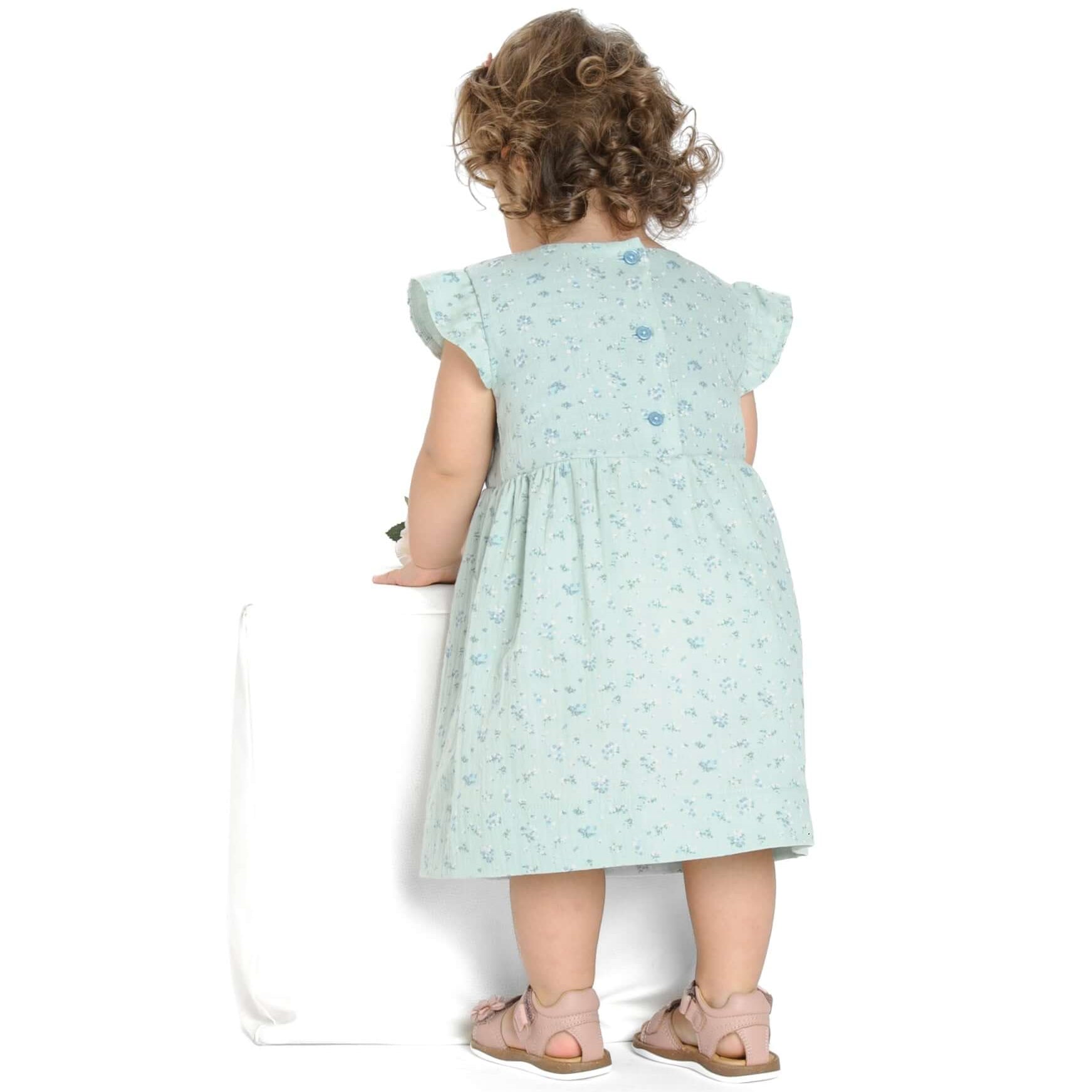 Schnittmuster Mädchenkleid ELLA – hintenansicht von Mädchen im Retro Kleid mit Volants und floralem Muster.