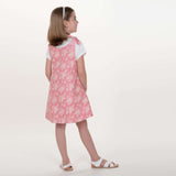 Schnittmuster Schürzenkleid JULE PDF 3-in-1, Mädchen in rosa Pinafore-Kleid mit Blumenmuster.