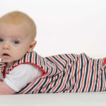 Schnittmuster Strampler LEO - Baby in gestreiftem Strampler liegt auf dem Bauch, süß und bequem.