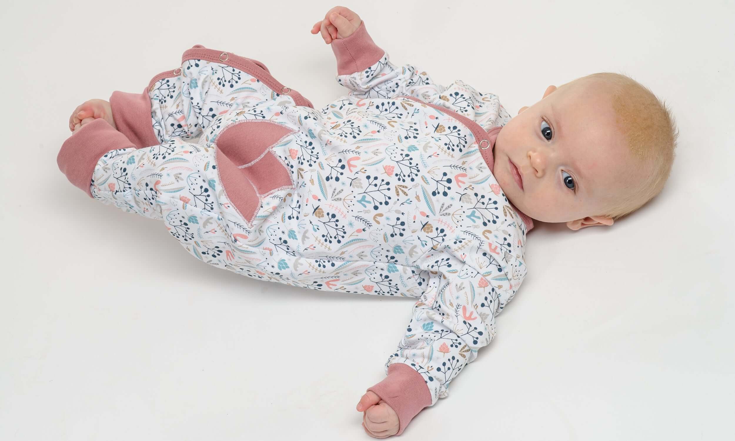 Schnittmuster Strampler LISA für Babys, gemütlicher langärmeliger Schlafoverall in buntem Muster.