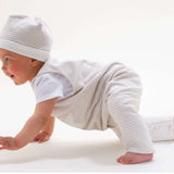 Schnittmuster Set Baby Strampler und Mütze in Verwendung, Baby mit gestreiftem Strampler und Mütze, crawlt spielerisch.