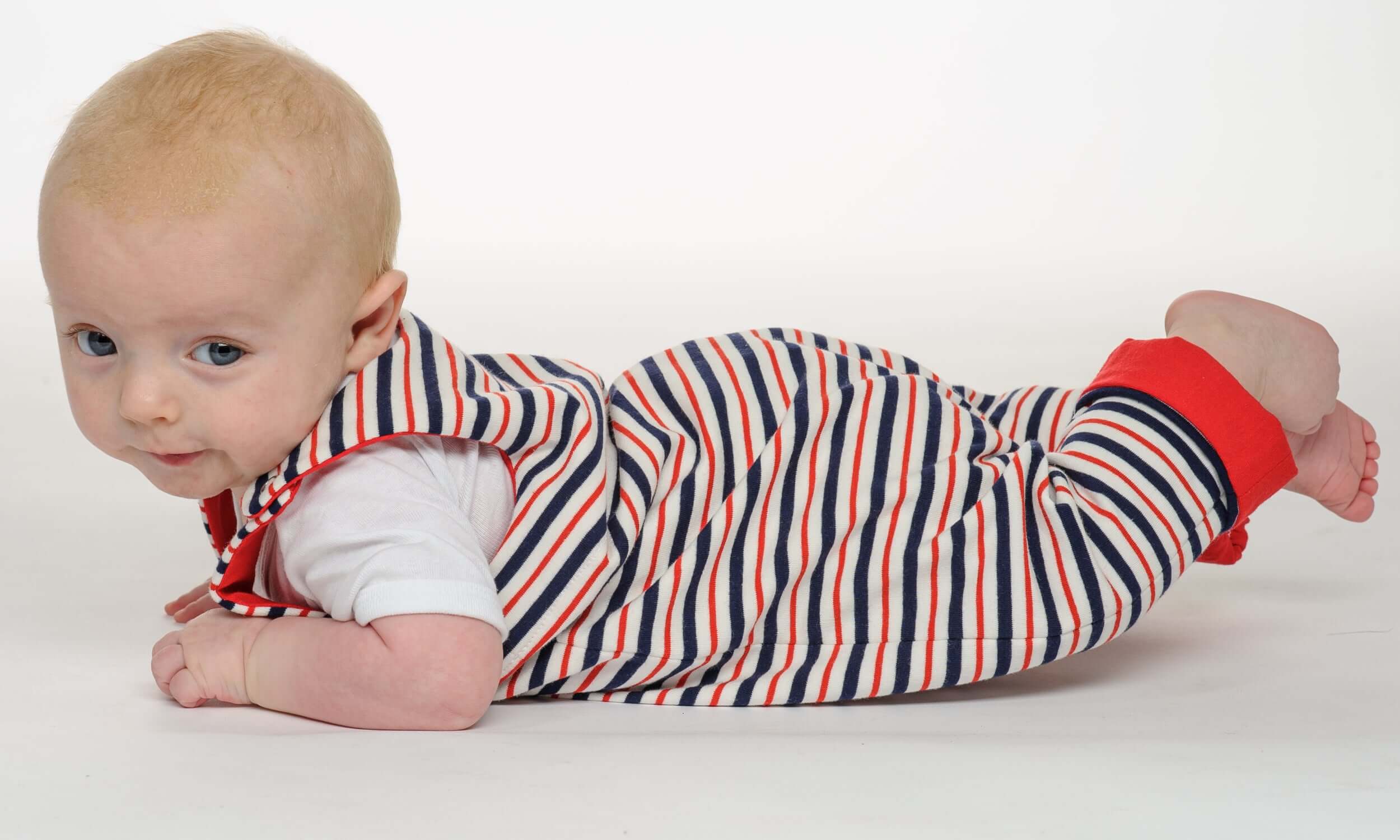 Baby in einem gestreiften Strampler aus dem Schnittmuster Strampler LEO, bequem und im Krabbelstil.