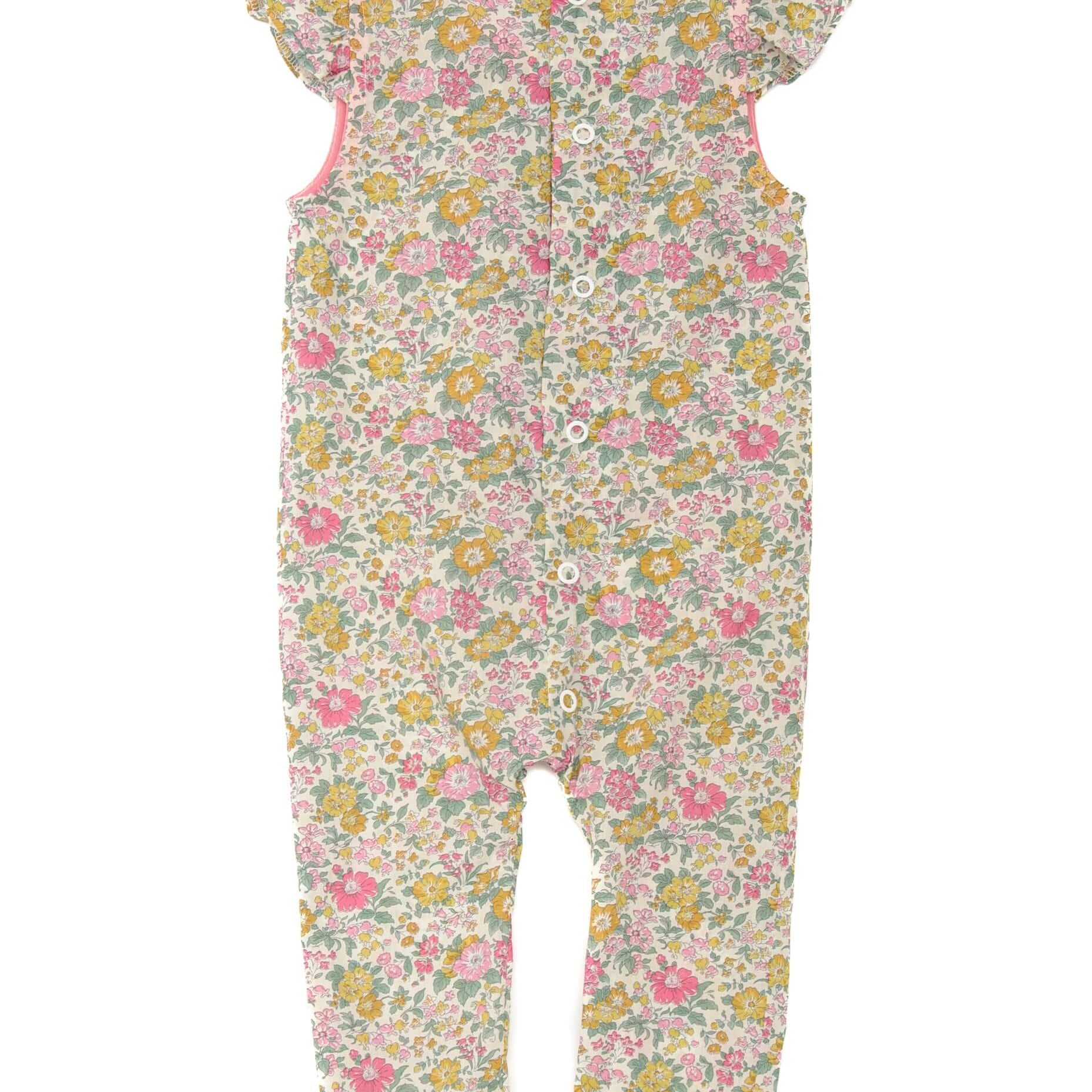 Schnittmuster Baby Overall MIA – Rückansicht des Baby-Jumpsuits mit floralem Muster und Volant-Ärmeln.