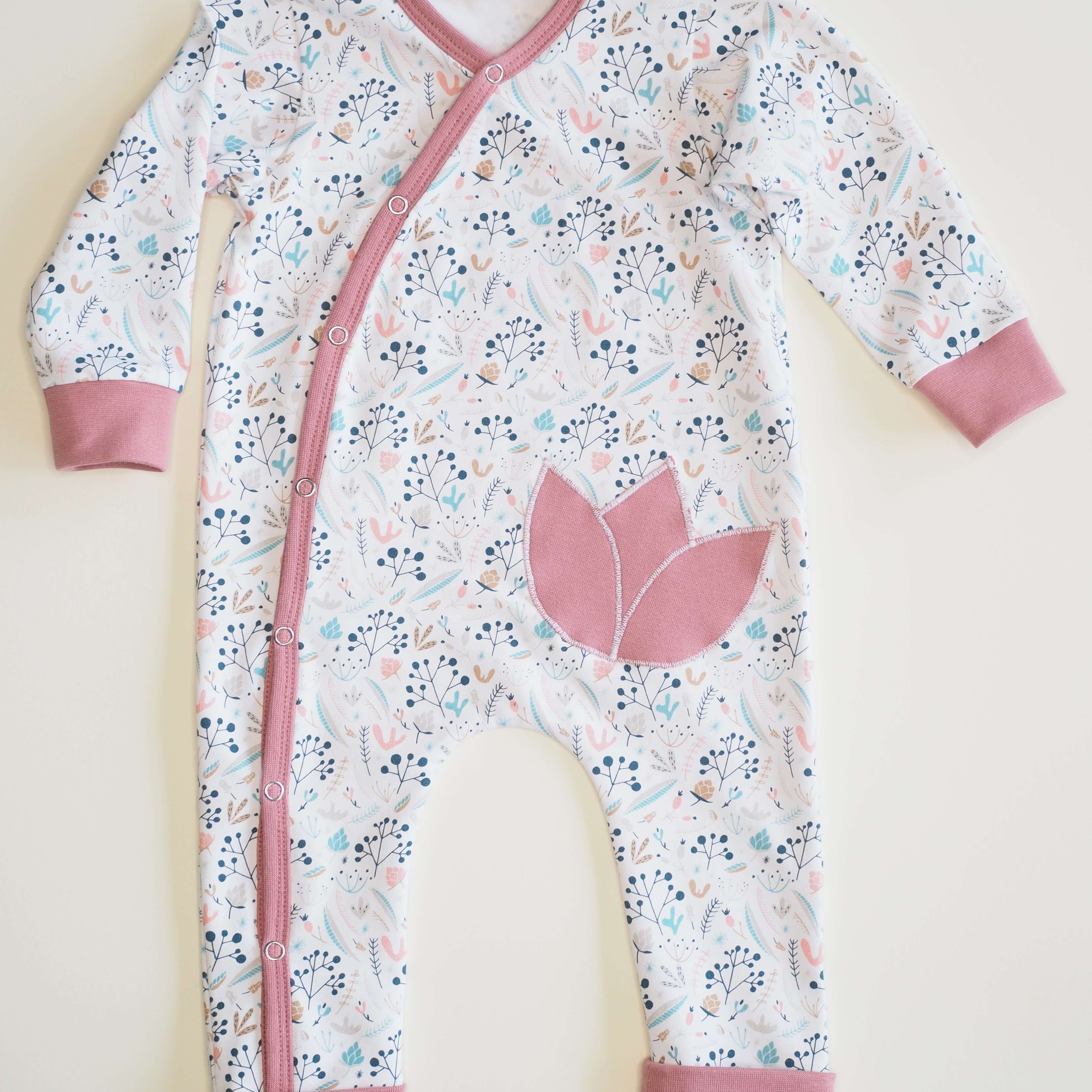 Schnittmuster Strampler LISA PDF für Baby, gemütlicher schlafoverall mit Blumenmuster und rosa Akzenten.