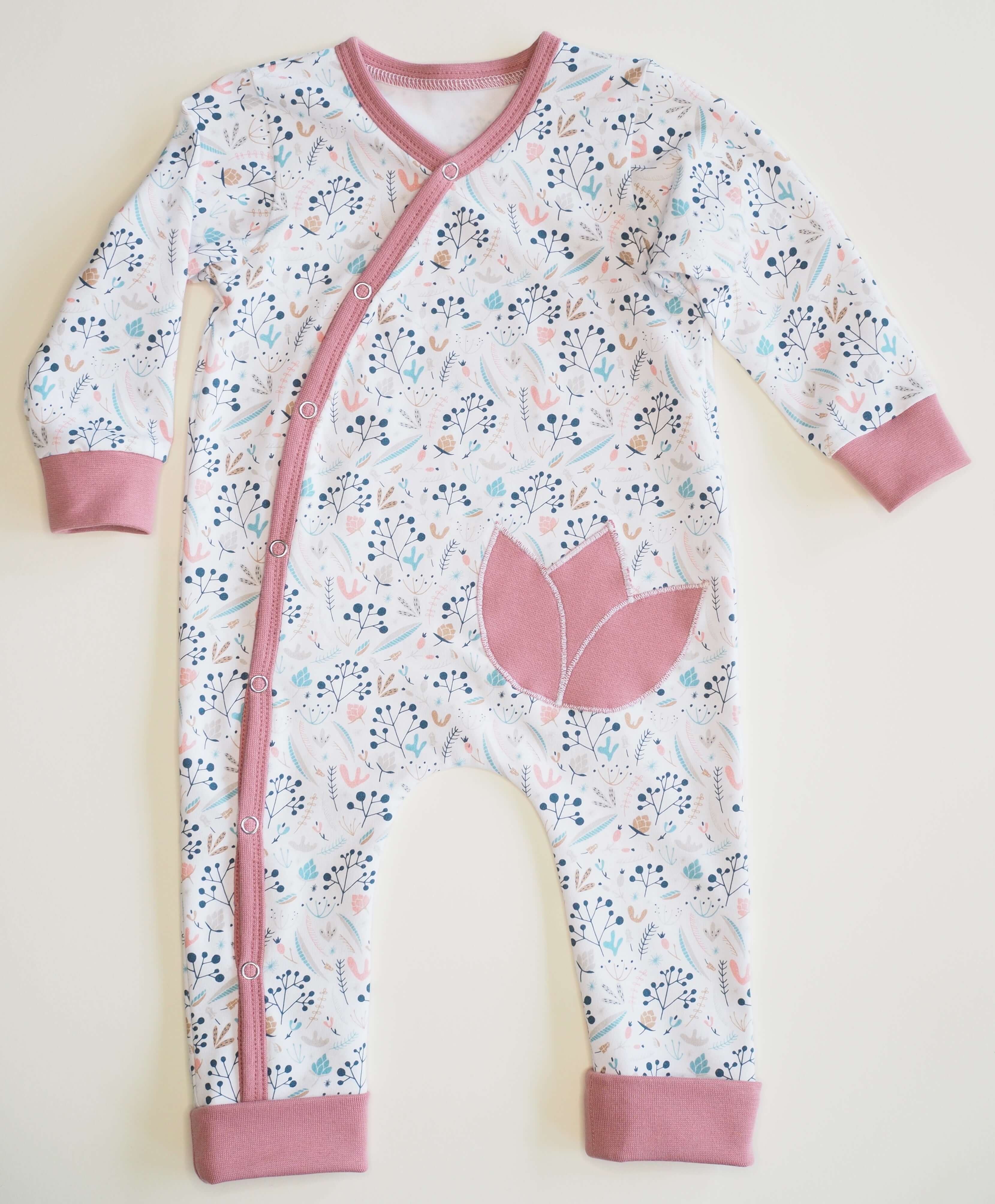 Schnittmuster Strampler LISA PDF für Baby, gemütlicher schlafoverall mit Blumenmuster und rosa Akzenten.