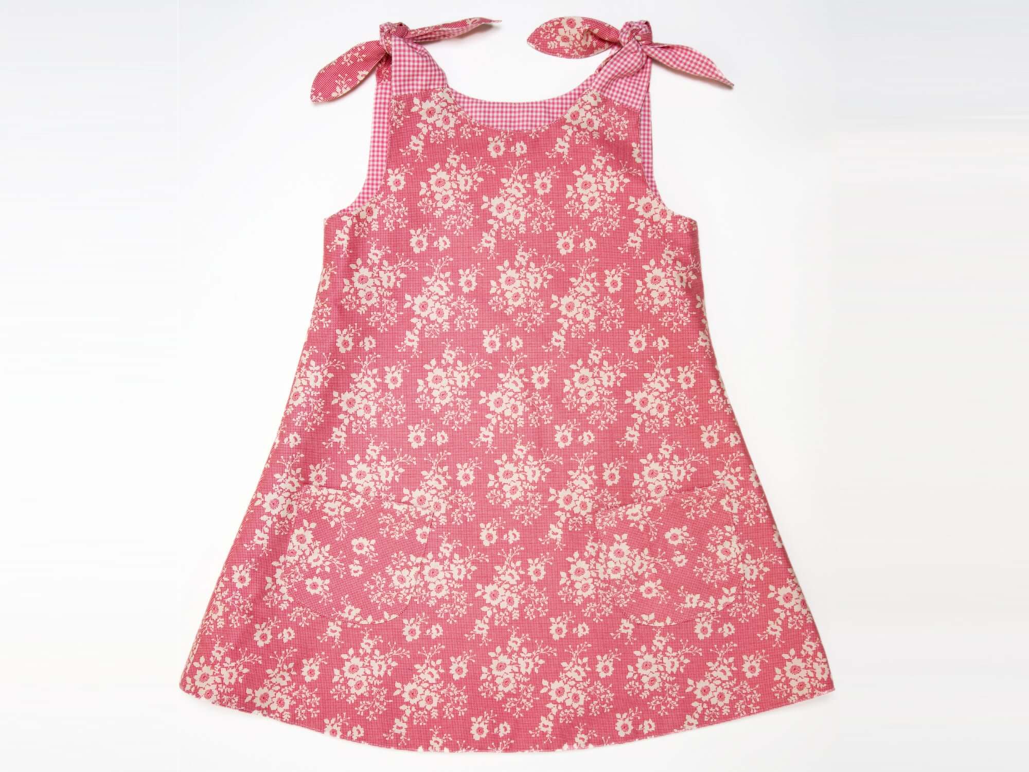Schnittmuster Mädchenkleid STEFFI in rosa mit Blumenmuster und schulterlangen Bändern für Mädchen.
