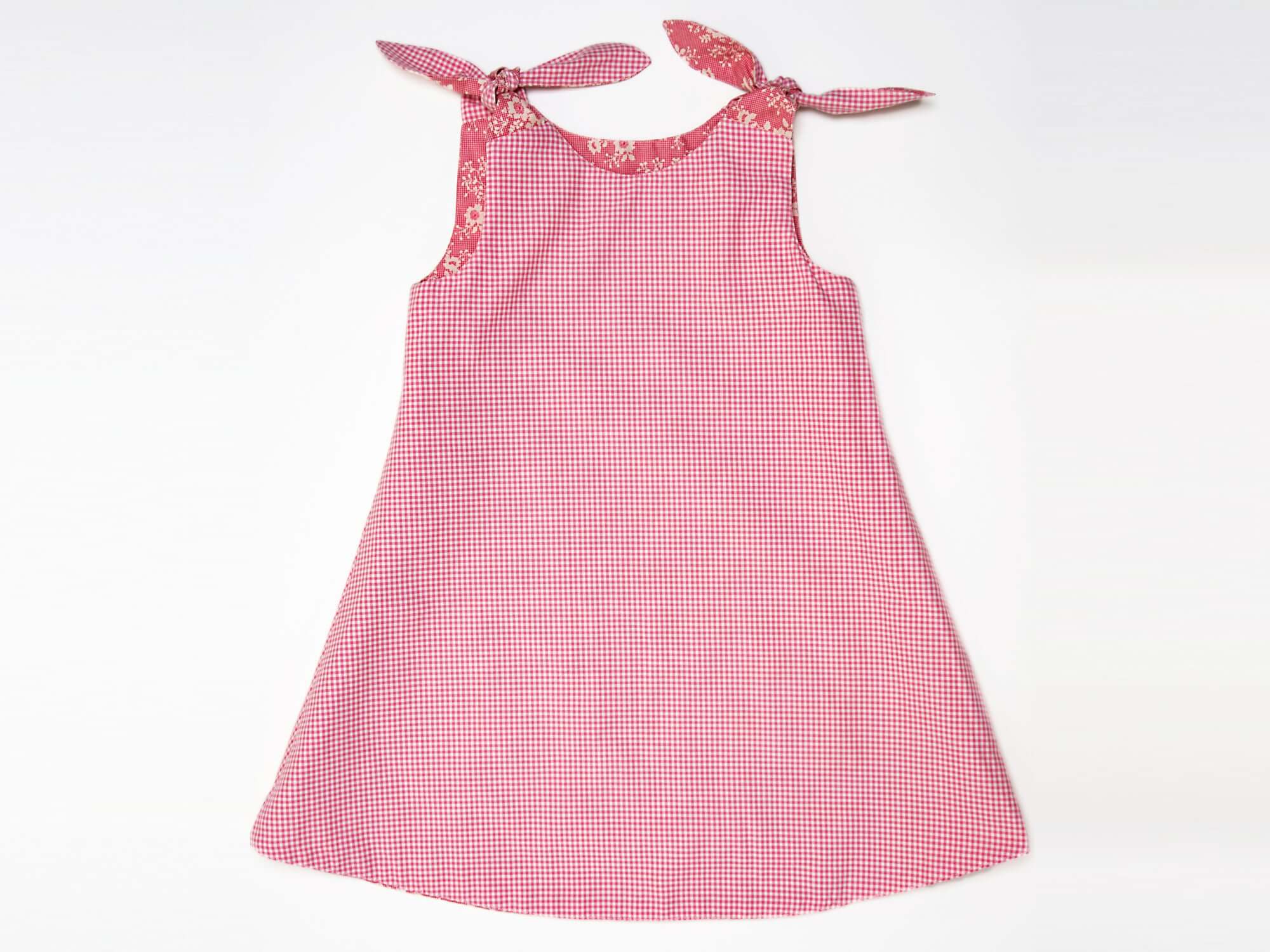 Schnittmuster Mädchenkleid STEFFI in rot kariert mit Schleifenknöpfen für Mädchen von Gr. 74 bis 152.