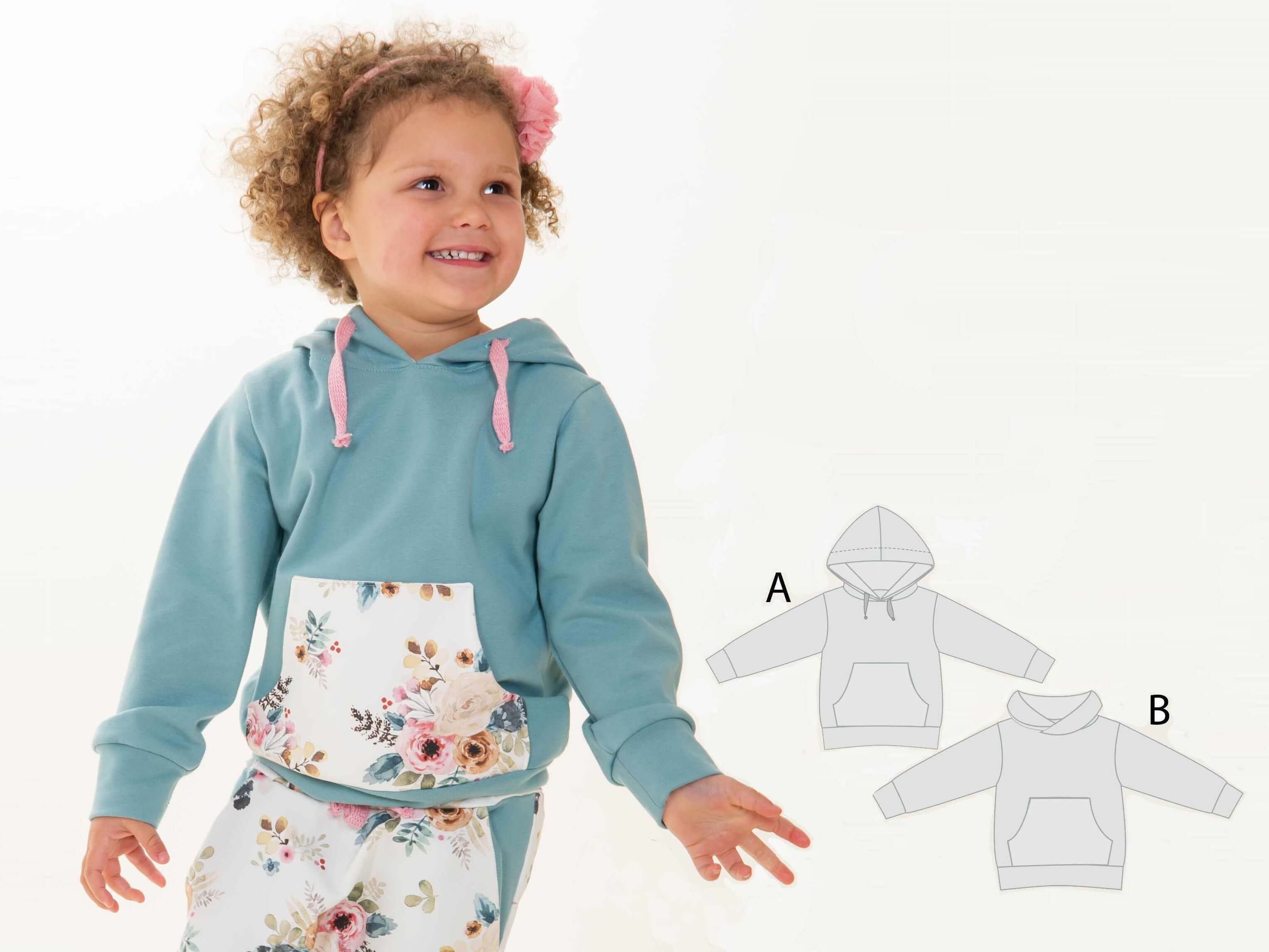 Schnittmuster Hoodie FLY: Mädchen in einem blauen Hoodie mit Blumen, zeigt 2-in-1 Schnittmuster Optionen A und B.