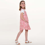 Schnittmuster Mädchenkleid STEFFI Gr. 74 - 152 präsentiert ein pinkes Kleid mit Blumenmuster, perfekt für den Sommer.