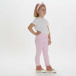 Schnittmuster Baby Kinder Leggings, Mädchen in rosa Leggings und weißem T-Shirt, bereit für den Alltag.