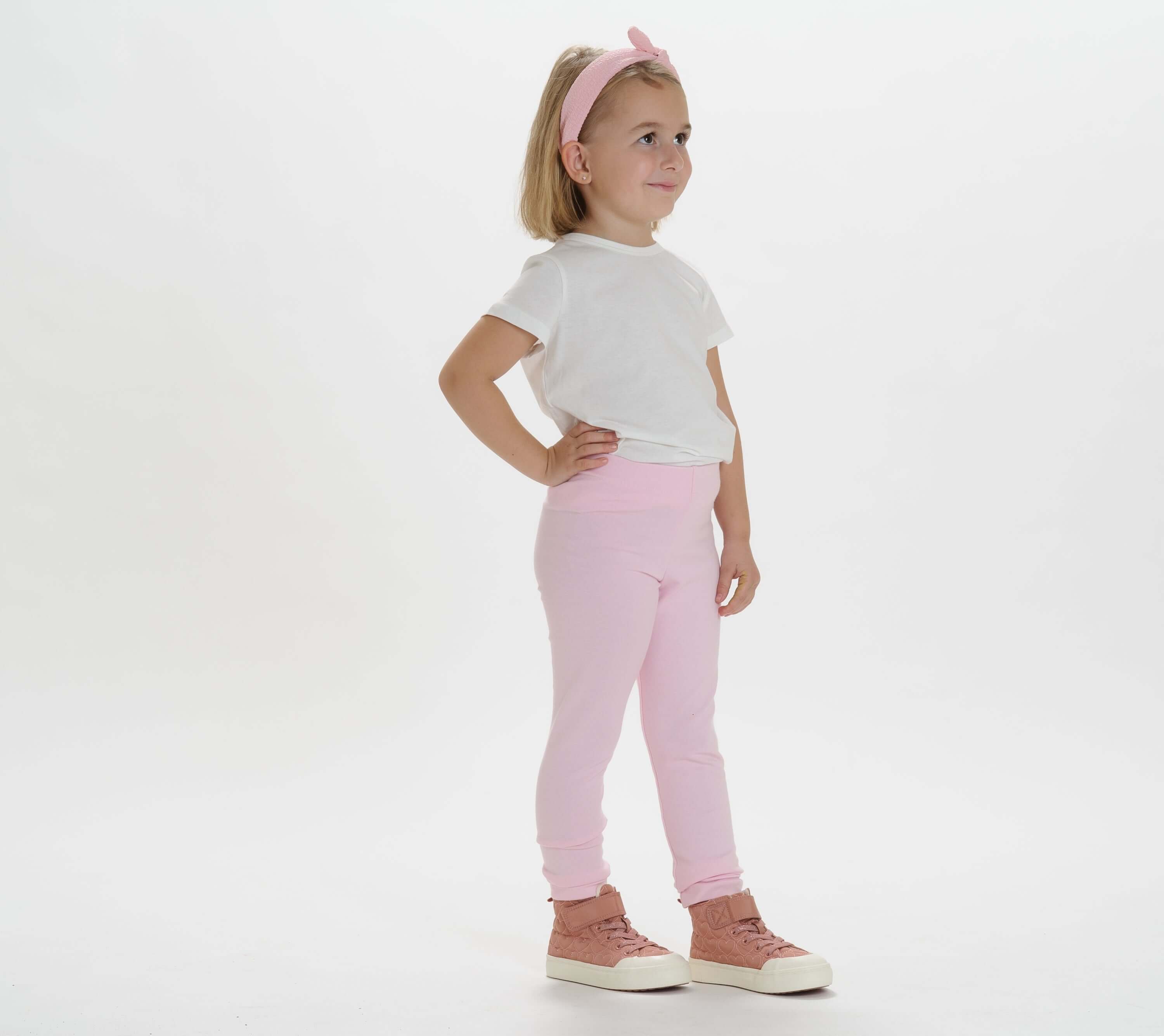 Schnittmuster Baby Kinder Leggings, Mädchen in rosa Leggings und weißem T-Shirt, bereit für den Alltag.