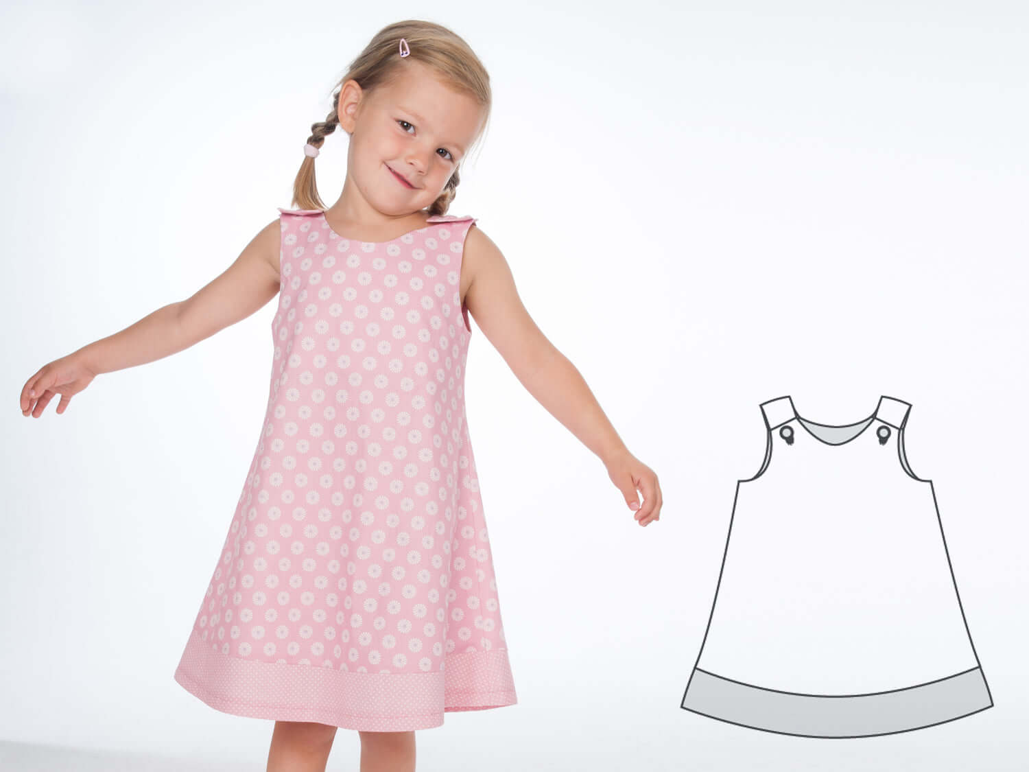 Mädchen trägt ein Schnittmuster Schürzenkleid JULE in rosa mit Punkten, daneben ist das Muster skizziert.