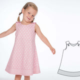Mädchen trägt ein Schnittmuster Schürzenkleid JULE in rosa mit Punkten, daneben ist das Muster skizziert.