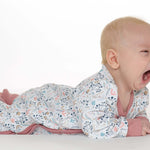 Schnittmuster Strampler LISA PDF Baby: Baby im bunten Strampler mit floralem Muster, schläft und gähnt.