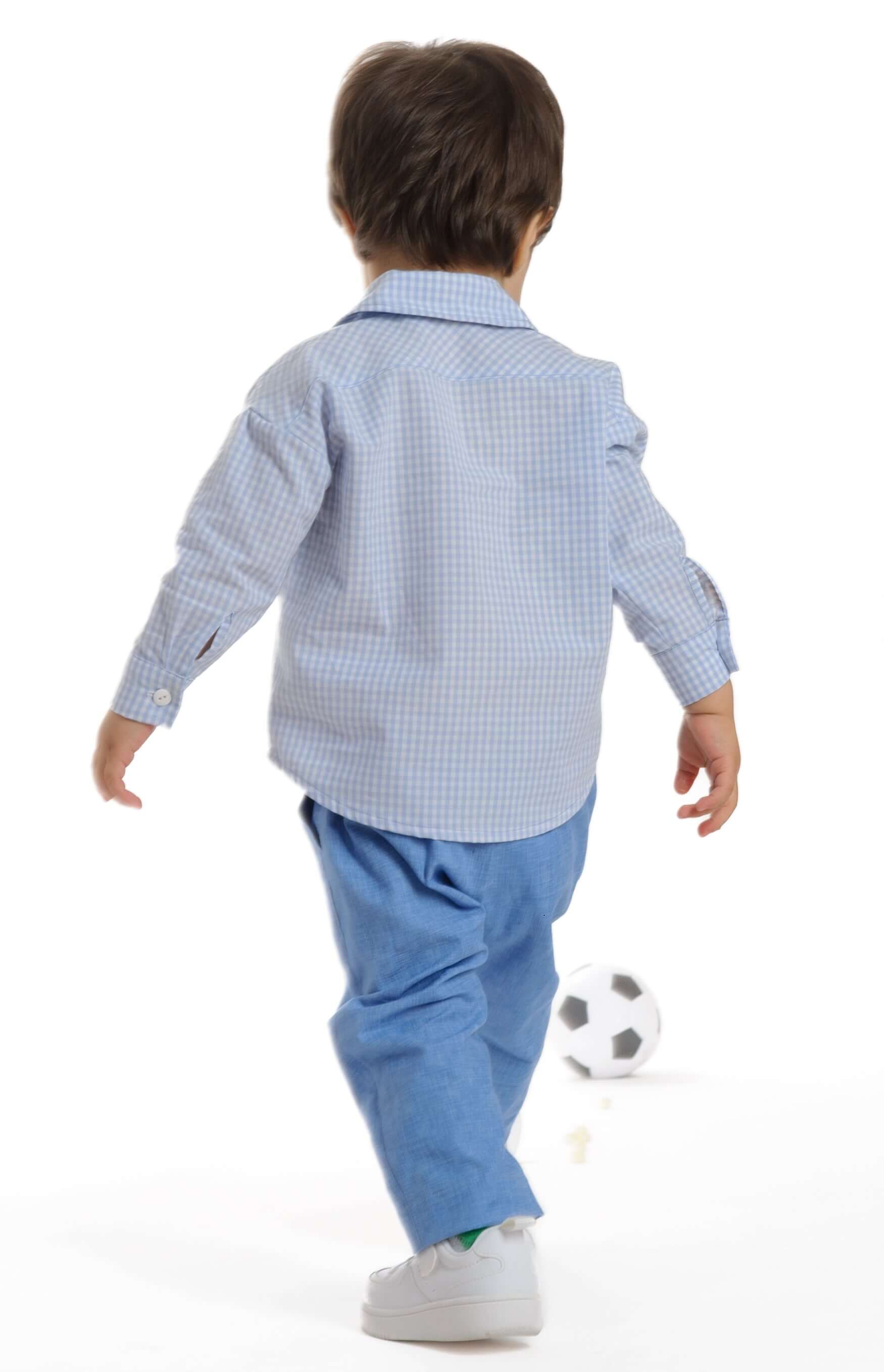 Schnittmuster Hemd für Baby und Kinder TOM auf einem Jungen, der einem Fußball hinterherläuft.