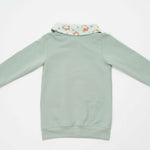 Schnittmuster Hoodie und Leggings ARWEN - Rückansicht des Hoodies in sanften Grüntönen mit floralem Kragen.