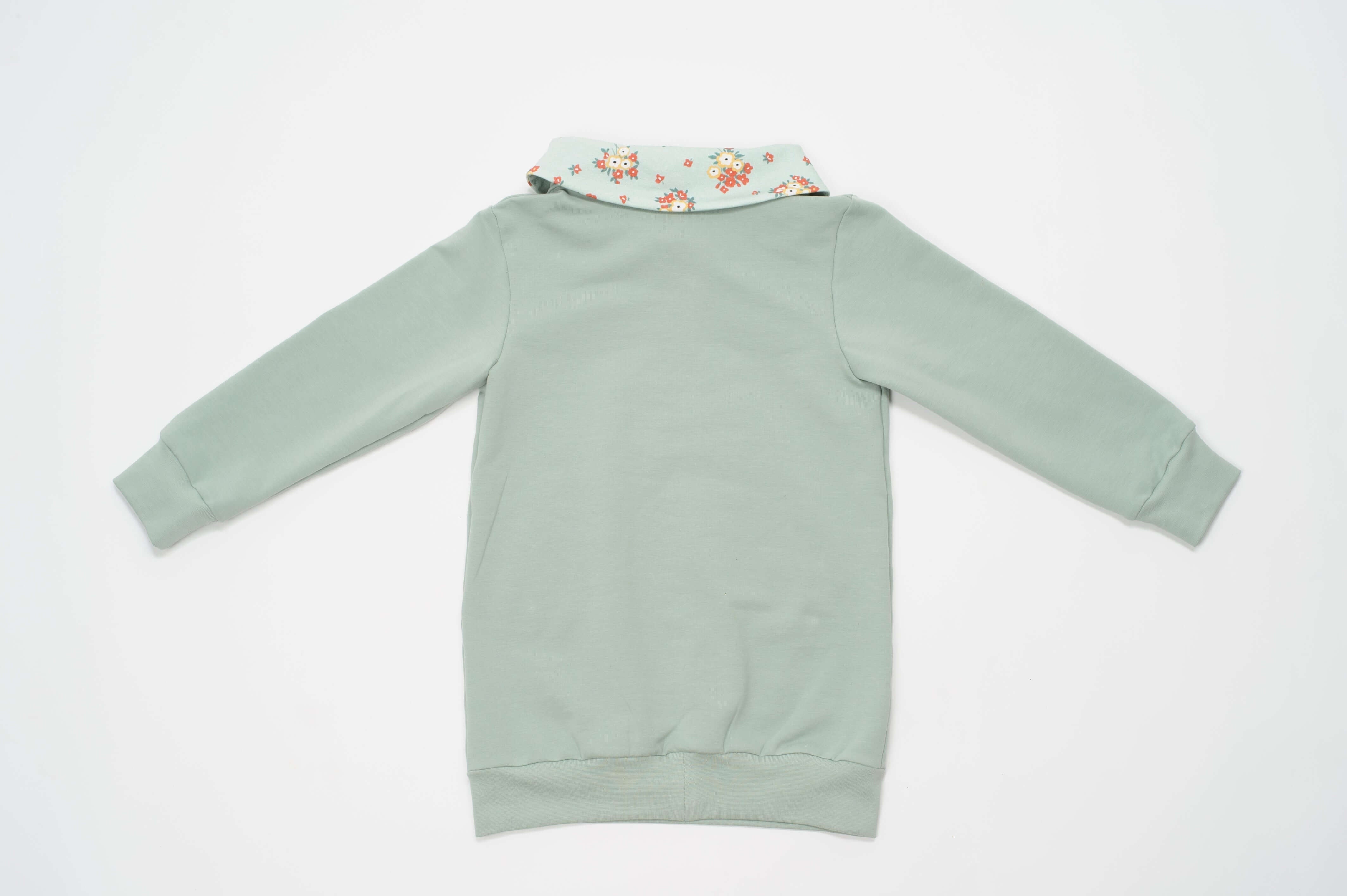 Schnittmuster Hoodie und Leggings ARWEN - Rückansicht des Hoodies in sanften Grüntönen mit floralem Kragen.