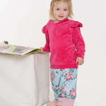 Schnittmuster Baby Sweatshirt für süßes Kind in pinkem Oberteil und gemusterter Hose, optimal für die kühlen Tage.