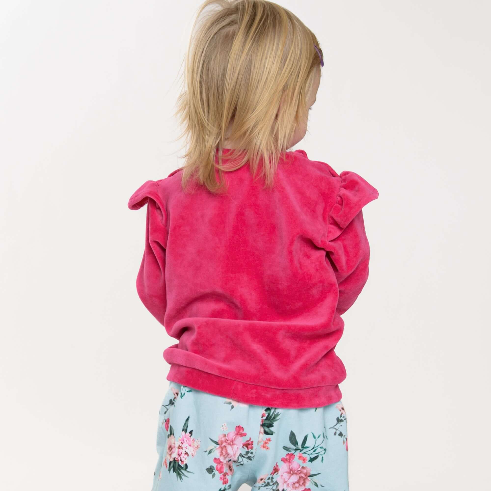 Schnittmuster Baby Sweatshirt in pink für Kinder mit Rüschen, Rückansicht, dass Teil des 2-in-1 PDF-Schnittmusters SOPHIE ist.