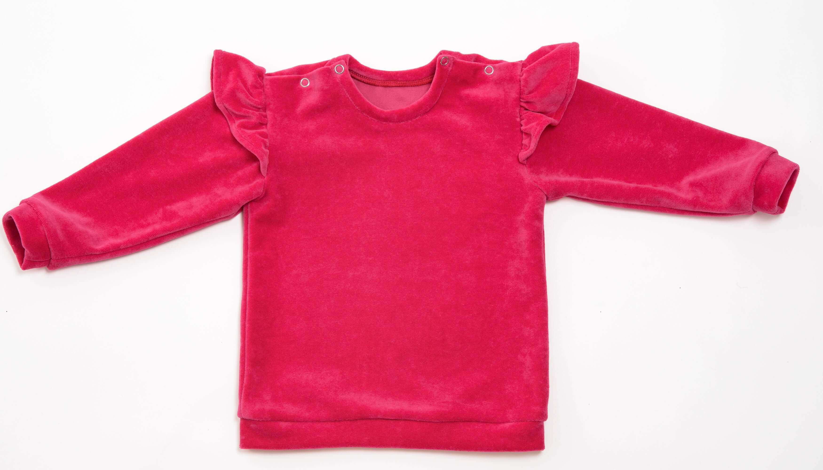 Schnittmuster Baby Sweatshirt in leuchtendem Pink mit Rüschendetail und Druckknöpfen.