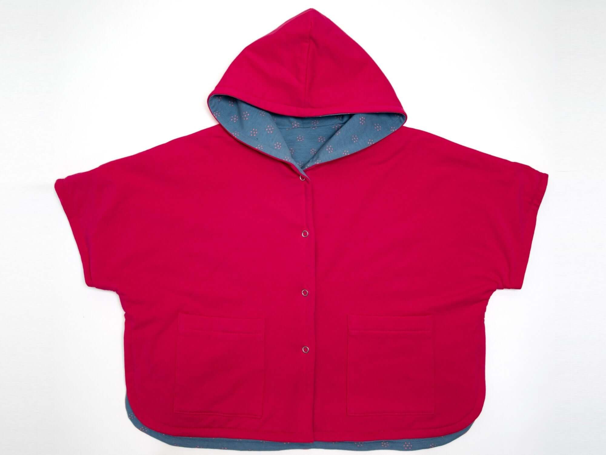 Schnittmuster Set PAULA DADO Poncho in leuchtendem Rot mit Kapuze und Taschen, ideal für Kinderoutfits.