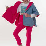 Mädchen trägt einen tollen Poncho nach Schnittmuster Mädchen Poncho PAULA in Pink und Blau. Perfekt für Kinder.