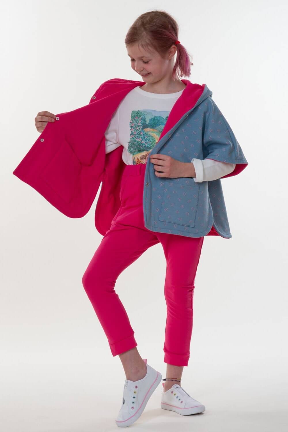 Mädchen trägt einen tollen Poncho nach Schnittmuster Mädchen Poncho PAULA in Pink und Blau. Perfekt für Kinder.