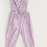 Schnittmuster Latzhose DAISY in zartem Lila mit Rüschen und elastischem Bund, ideal für Kinder von 6 Monaten bis 7 Jahren.