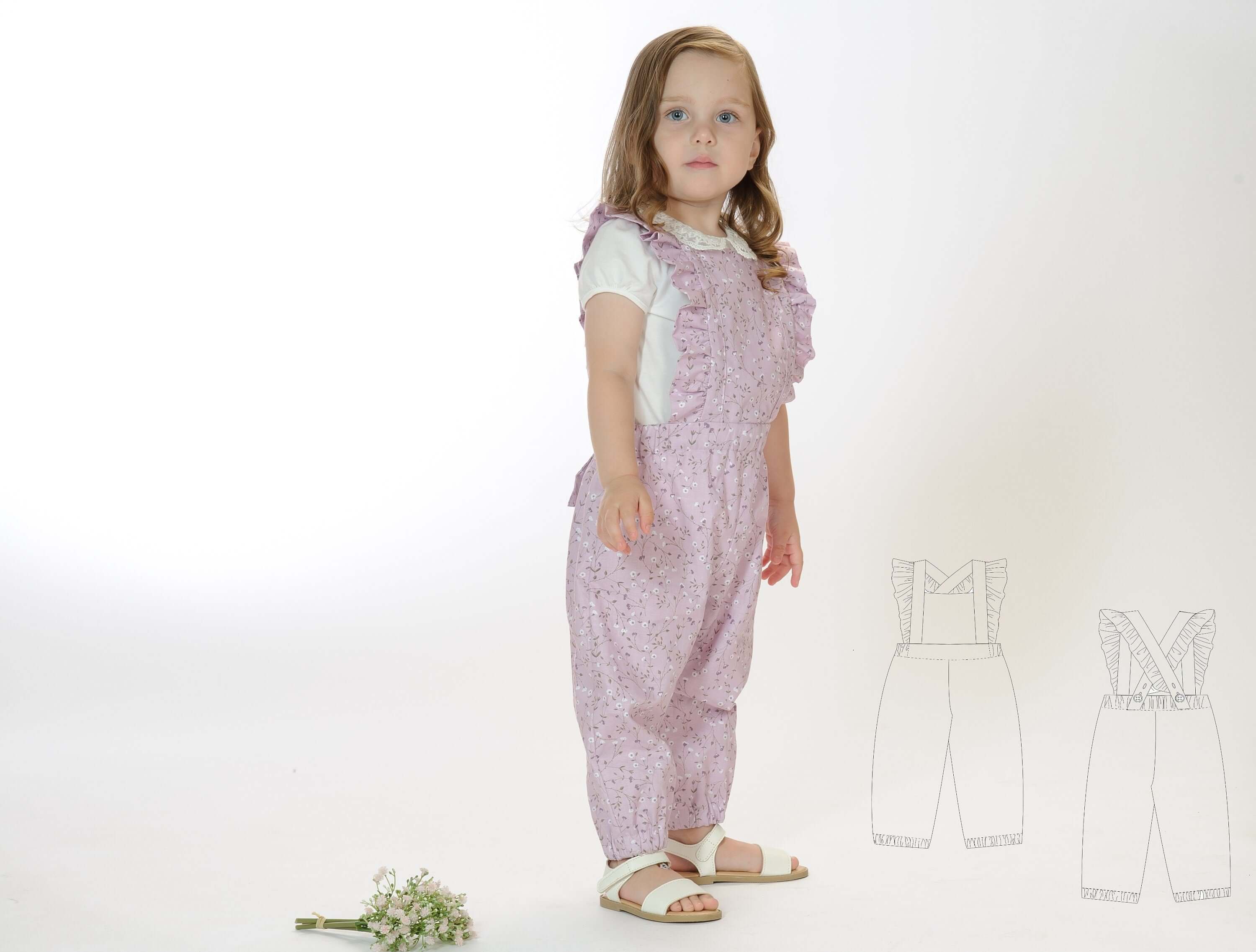 Schnittmuster Latzhose DAISY PDF in rosa für Kinder, Größen 68/74-116/122, mit Rüschen und gekreuzten Trägern.