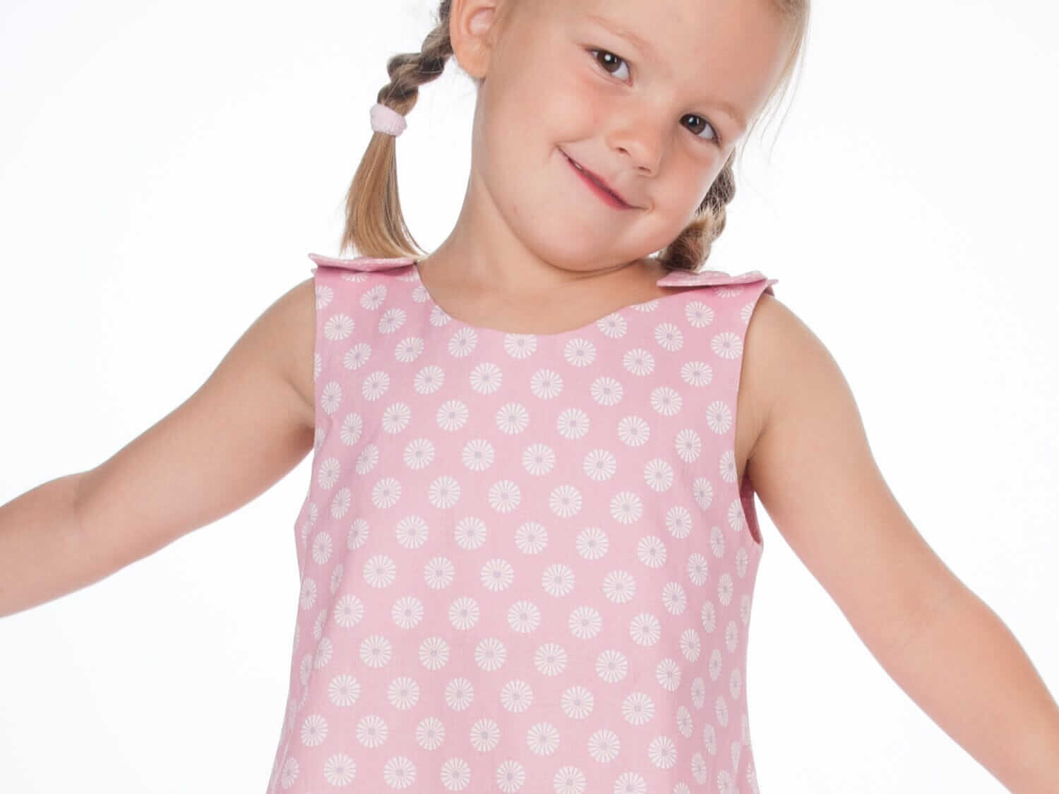 Schnittmuster Mädchenkleid STEFFI Gr. 74 - 152, pinkes Babykleid mit Blumenmuster, fröhliches Mädchen präsentiert das Kleid.