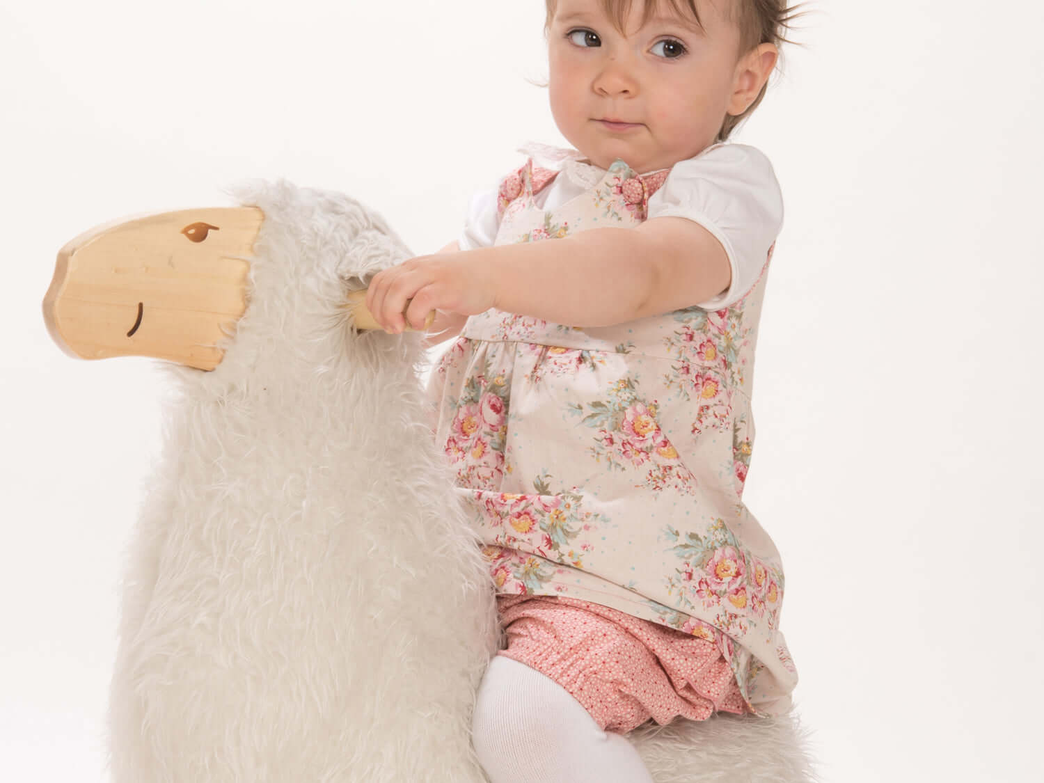Schnittmuster Baby Twinset Babykleid Hängerchen und Pumphose - Baby sitzt auf einem Plüschtier.