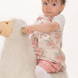 Schnittmuster Baby Twinset Babykleid Hängerchen und Pumphose - Baby sitzt auf einem Plüschtier.