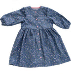 Schnittmuster Kleid MIMI PDF 2-in-1 for girls in blue floral fabric, long sleeves and button-down design.