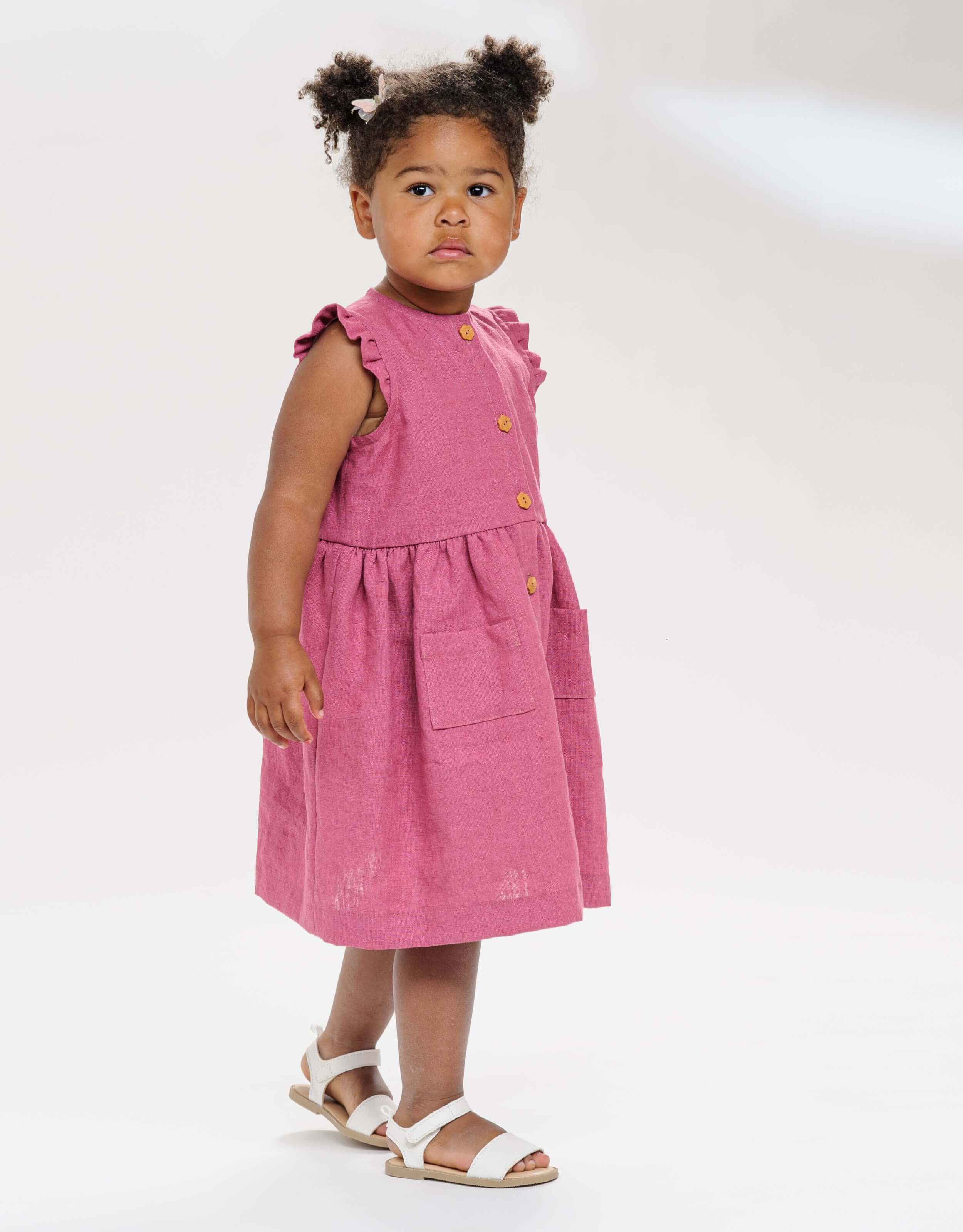 Schnittmuster Kleid MIMI PDF 2-in-1, verspieltes Mädchenkleid in Rosa mit Taschen und Knöpfen.