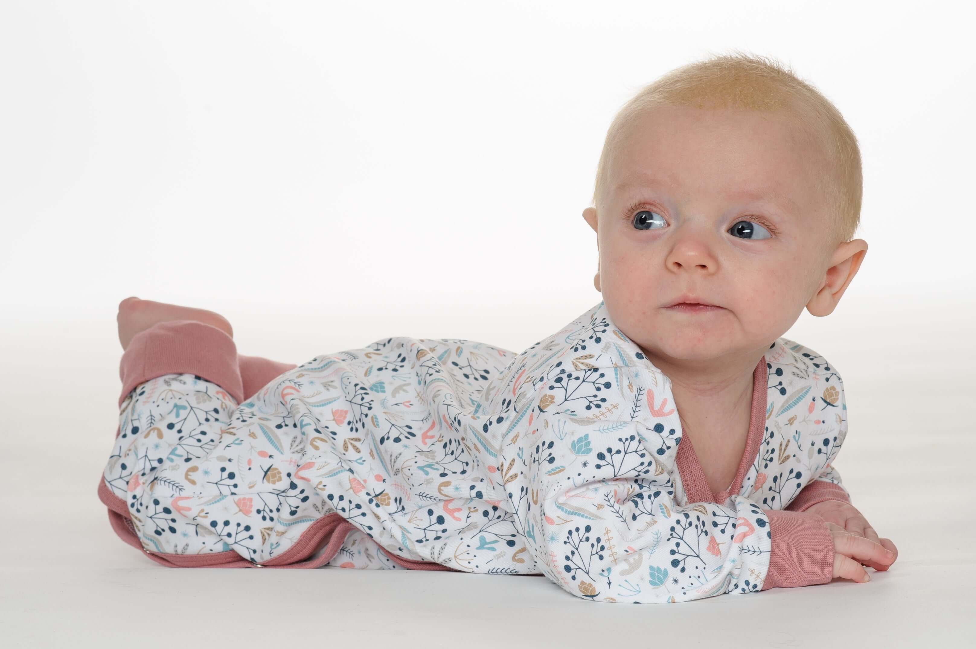 Schnittmuster Strampler LISA Modell: Baby in einem bunten Strampler mit Blumenmotiven, bequemer Schlafanzug.